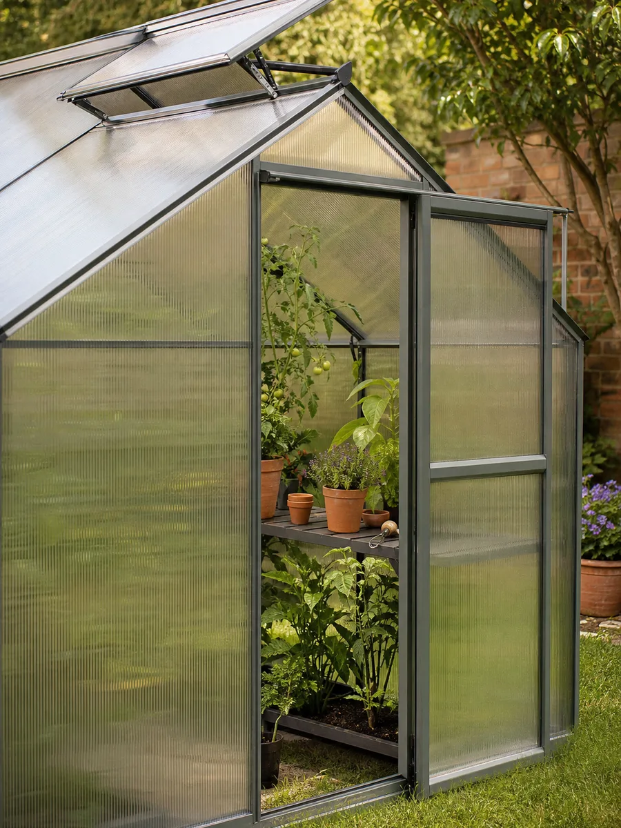 Serre de jardin en polycarbonate avec structure aluminium installée sur une pelouse